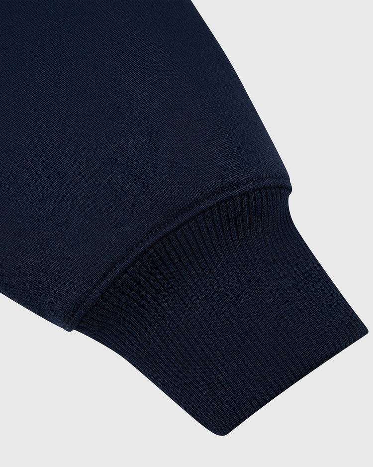 Close-up of the Ebbets Field NOTRE DAME HOODIE NAVY sleeve, highlighting the ribbed cuff detail against a light gray background.