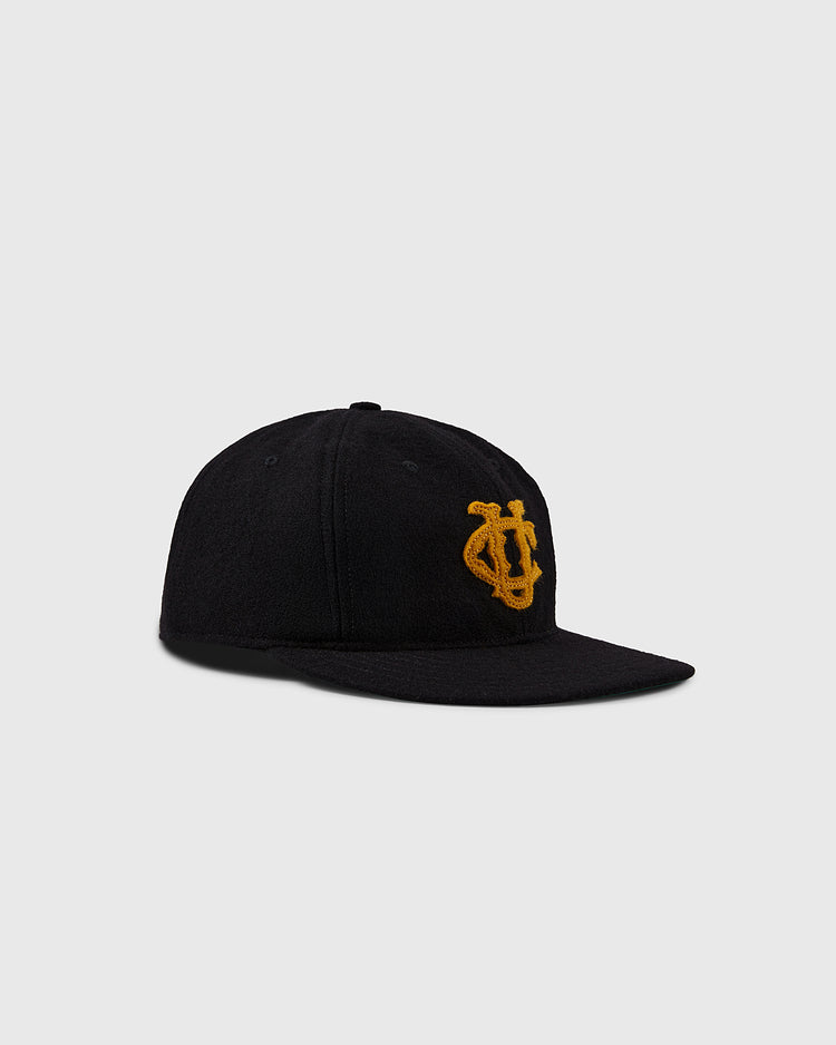 The EFF University of Colorado 1924 Vintage Ballcap is a black flat-brim cap with a yellow embroidered interlocking UC logo on the front, shown against a plain light gray background.