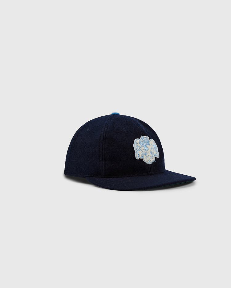 The EFF University of North Carolina Mascot Vintage Ballcap features a navy blue flat brim and an embroidered light blue and white floral design on the front, shown against a plain light gray background.
