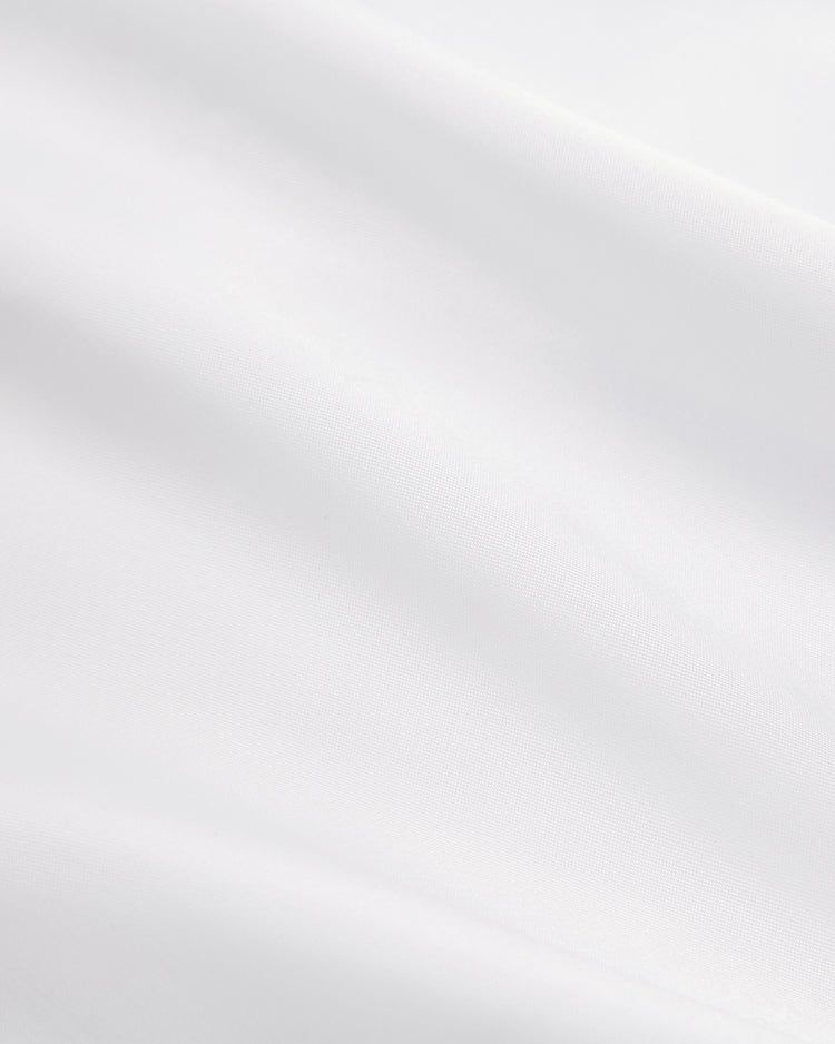 Close-up of smooth white fabric with soft folds and gentle shadows, capturing the minimalistic style of Ebbets Field's Muhammad Ali Vintage Inspired Boxing Trunks.