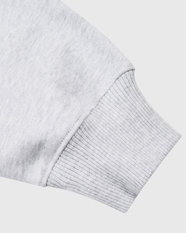 Close-up of a light gray sleeve with ribbed cuff from the Ebbets Field Muhammad Ali Chest Embroidered Heavyweight Cotton Terry Pullover Hoodie, shown against a plain white background.