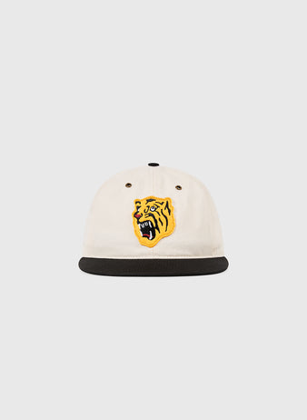 The Osaka Tigers Cotton Twill Ballcap by Ebbets Field is a white cap with a black brim and yellow tiger head embroidery, blending classic Japanese baseball style with the spirit of Koshien Field.