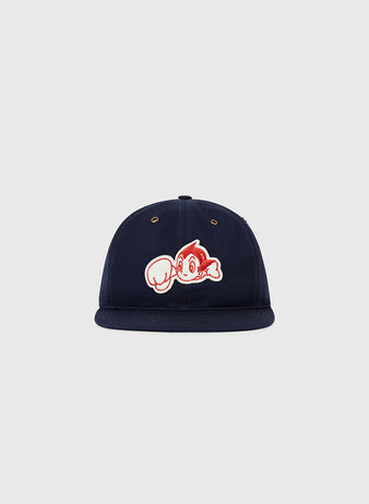 The Ebbets Field Sankei Atoms Cotton Twill Ballcap is a navy cap with a cartoon Astro Boy patch showing his iconic large fist on the front, displayed against a plain light gray background.