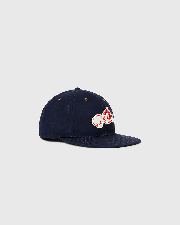 The Ebbets Field Sanke Atoms Cotton Twill Ballcap is a navy blue Japanese-style cap with a flat brim, featuring an embroidered red and white cartoon monkey face logo on the front, set against a light gray background.