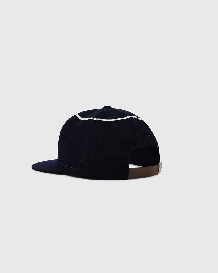 The Ebbets Field Los Angeles Angels 1961 MLB Authentic Wool Ballcap features dark navy wool, white stitching, a brown adjustable strap, and is shown on a plain light gray background.