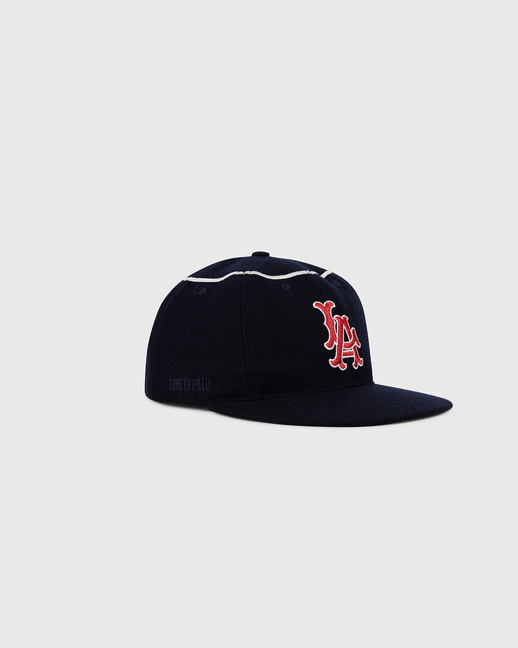 The Ebbets Field Los Angeles Angels 1961 MLB Authentic Wool Ballcap in navy features a red and white LA logo on the front, shown against a plain light gray background.