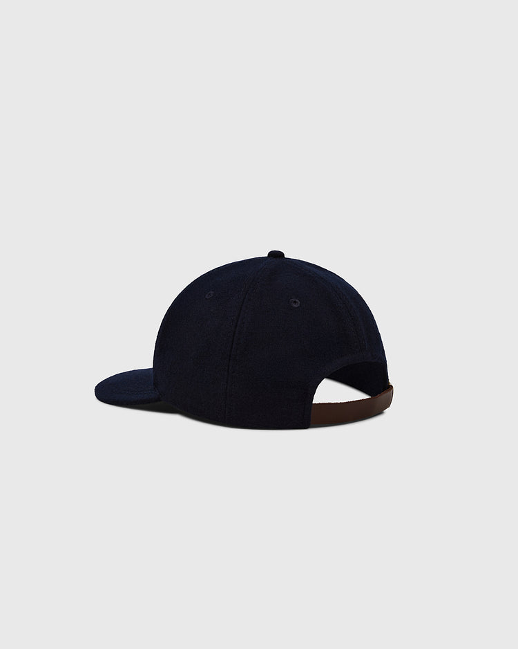 The Ebbets Felt 'E' Wool Ballcap by Ebbets Field is shown from the back in navy wool, with a brown adjustable strap and curved brim, set against a plain light gray background—classic vintage style.