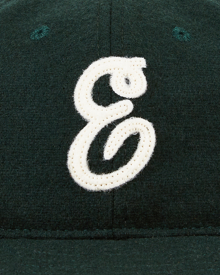 A close-up of the Ebbets Field Ebbets Felt 'E' Wool Ballcap, a dark green vintage-style baseball cap with a large white cursive