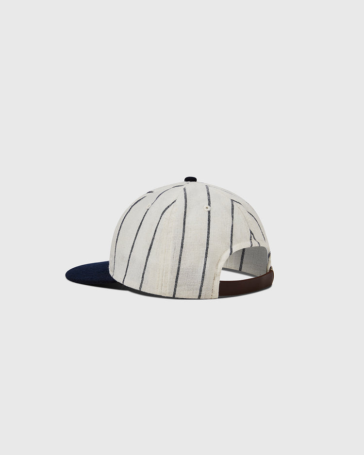 The Ebbets Field Ebbets Felt 'E' Wool Pinstripe Ballcap features white and black vertical pinstripes, a dark blue brim, an adjustable brown strap, and classic wool broadcloth, shown on a plain light gray background.