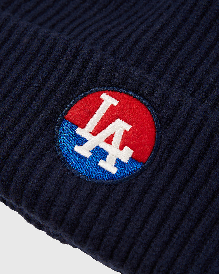 Close-up of the Ebbets Field Los Angeles Angels (PCL) Patch Logo Ribbed Beanie in navy blue, featuring ribbed knit fabric and a circular red and blue patch with an embroidered LA logo inspired by the Pacific Coast League.