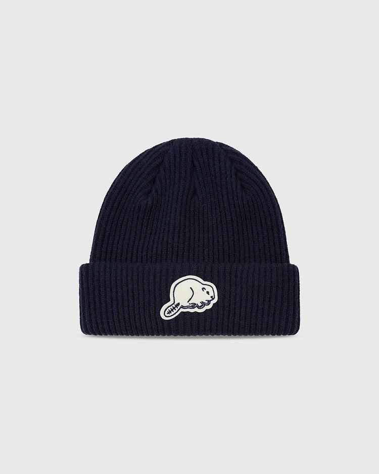 The Ebbets Field Portland Beavers Felt Logo Ribbed Beanie is a navy ribbed knit with a folded brim and a white beaver felt patch on the front, set against a plain light gray background—ideal for Portland Beavers fans.