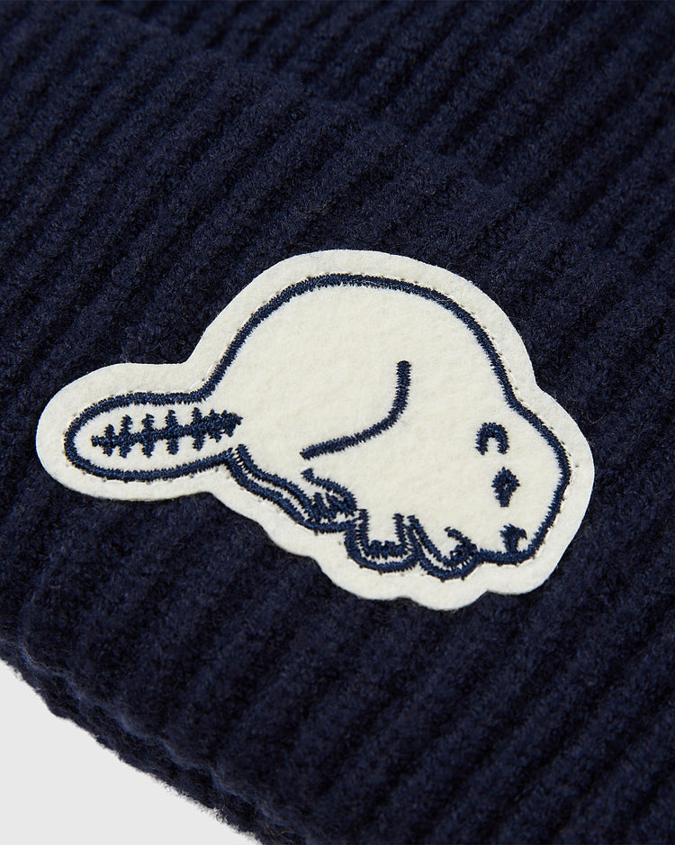 A close-up of the Ebbets Field Portland Beavers Felt Logo Ribbed Beanie in navy, featuring a white felt beaver patch outlined in dark blue—a perfect choice for PCL baseball memorabilia fans.