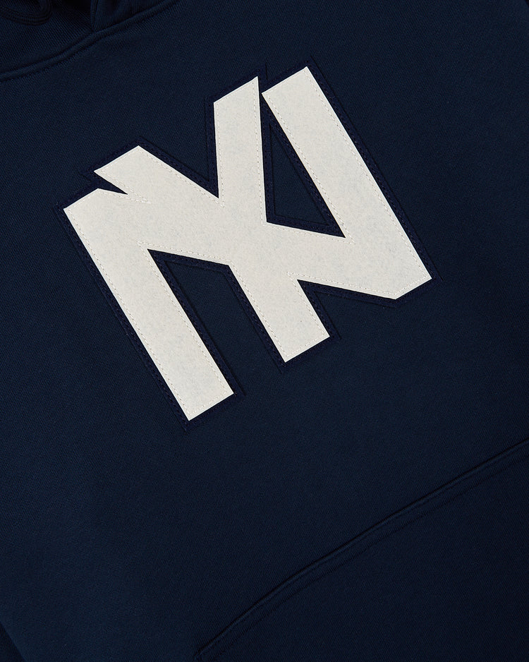 The Ebbets Field Brooklyn Eagles Heavyweight Cotton Terry Pullover Hoodie features a large, stylized white MN logo on navy blue, celebrating the legacy of the Negro Leagues.