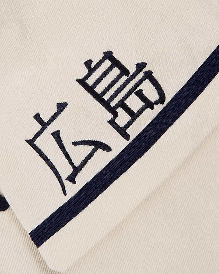 Close-up of the Ebbets Field Hiroshima Carp Cotton Twill Baseball Jersey with dark blue trim and Japanese kanji embroidery, inspired by vintage baseball style.