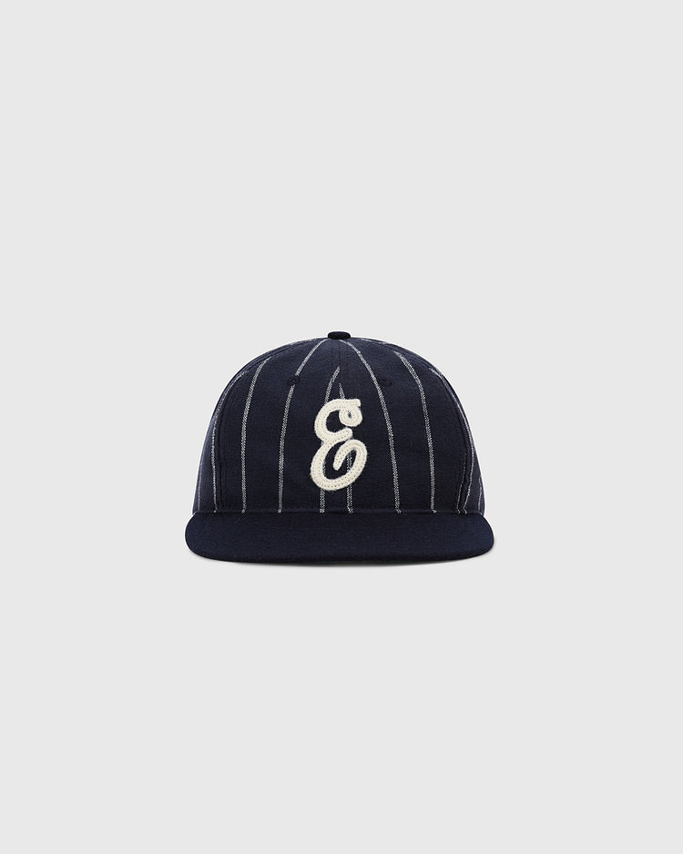 The Ebbets Field Ebbets Felt 'E' Wool Pinstripe Ballcap features navy blue wool broadcloth, thin white pinstripes, and a white embroidered letter E on the front, shown against a plain light gray background.