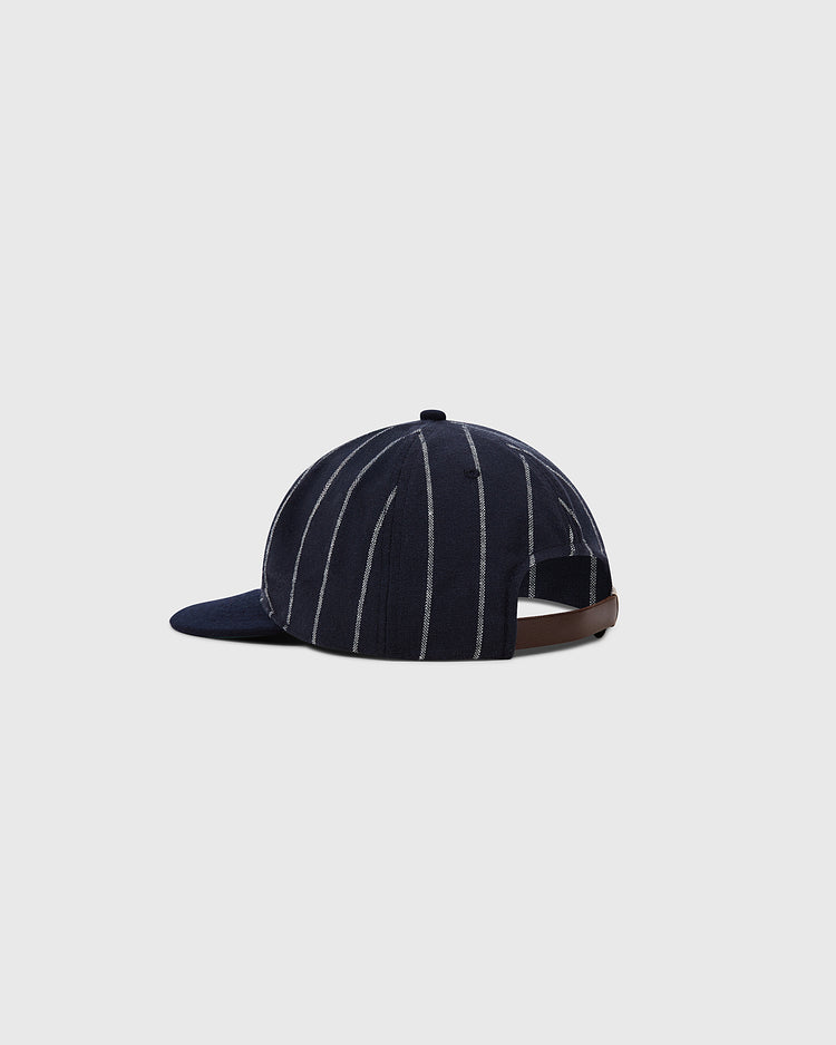 The Ebbets Field Felt 'E' Wool Pinstripe Ballcap is a vintage dark blue cap with thin white pinstripes, a curved brim, and an adjustable brown strap, shown on a plain light gray background.