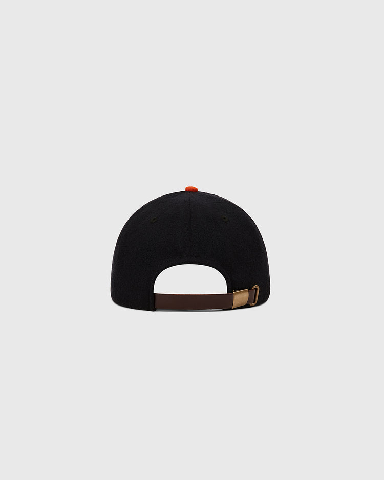 The Ebbets Field Tokyo Giants 1952 Authentic Wool Ballcap in black features an adjustable brown strap with a metal buckle and a red top button, inspired by the classic 1952 style, shown from the back on a plain light gray background.