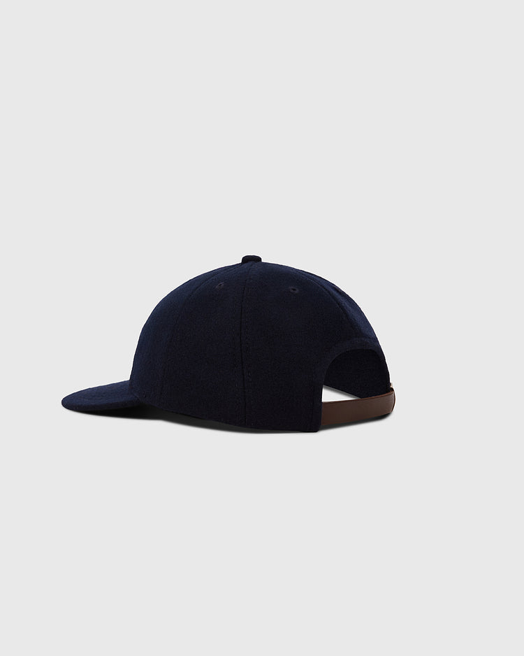 The Ebbets Field Hiroshima Carp 1959 Authentic 8-Panel Wool Ballcap is shown from the back. It’s navy blue with a curved brim and a brown adjustable strap, set against a plain light gray background.