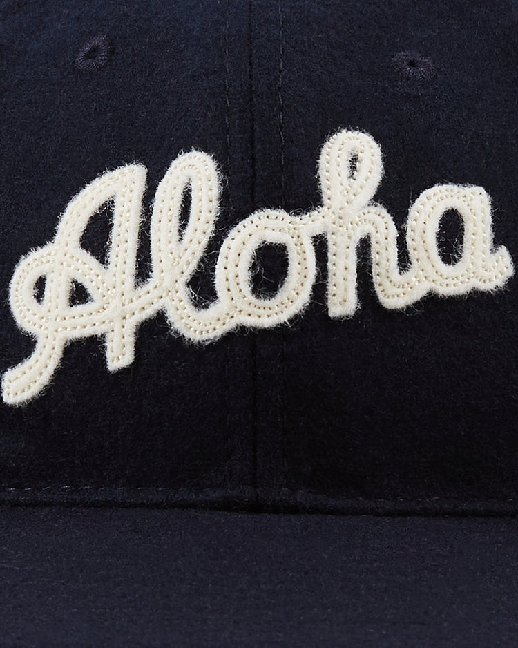 A close-up of the Ebbets Field Aloha 100th Infantry 1942 Authentic Ballcap in navy, featuring