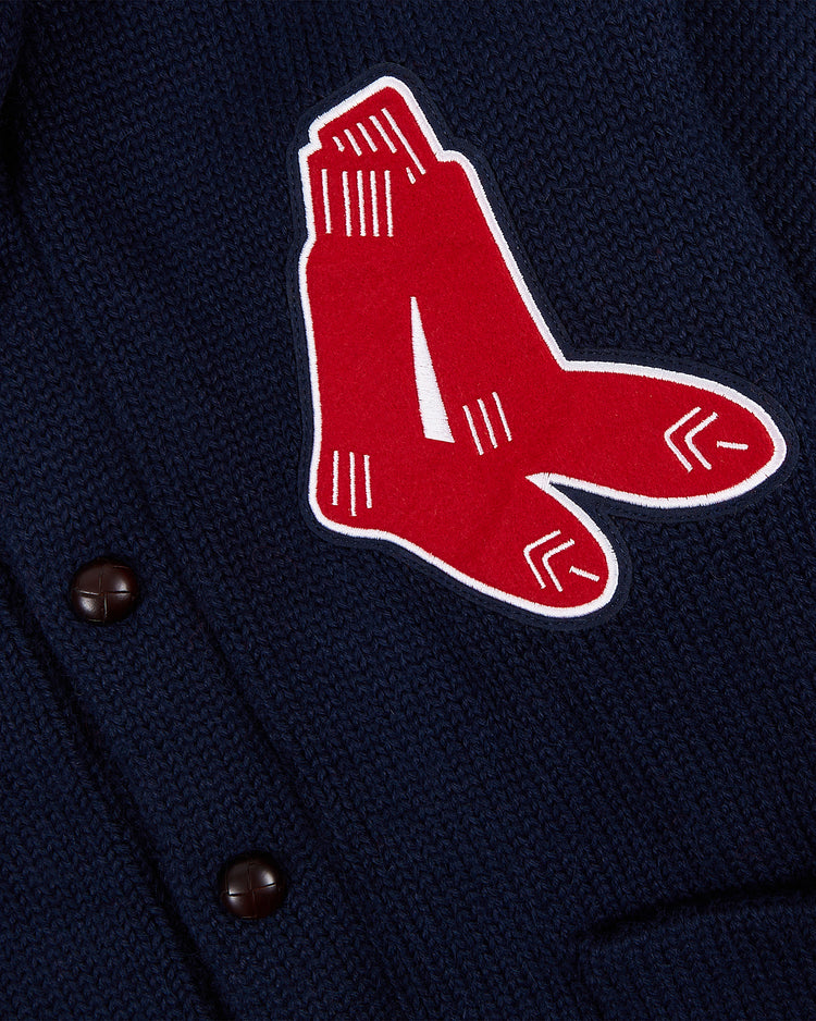 A close-up of the EFF Boston Red Sox 1924-1960 Wool Shawl Collar Sweater in navy, showcasing the hanging socks logo patch and black buttons on the left side.