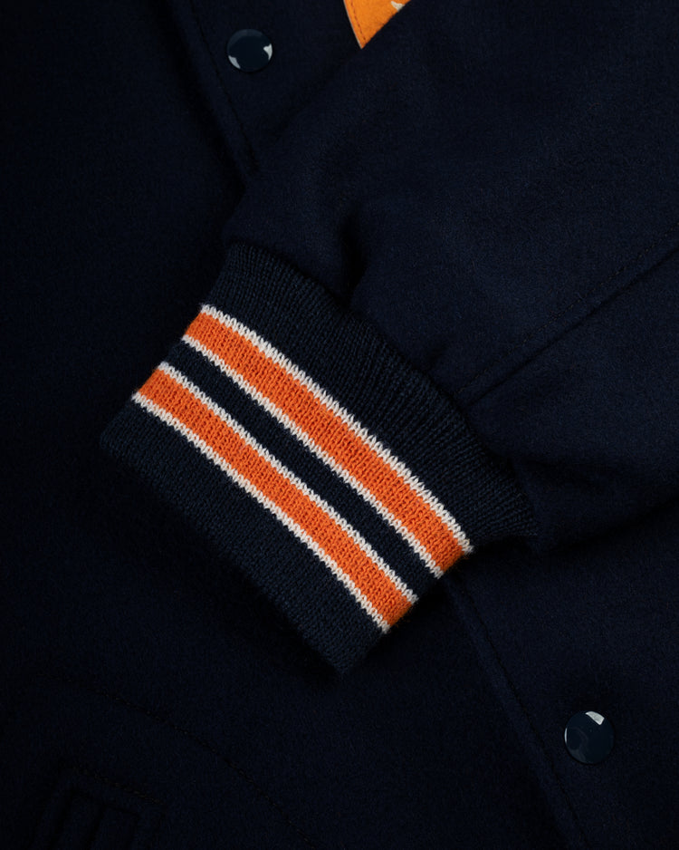 Close-up of the EFF Houston Astros 1965 Authentic All Wool Varsity Jacket sleeve, showing ribbed cuffs with orange, white, and navy stripes, snap buttons, and textured wool—a tribute to the Astrodome era.