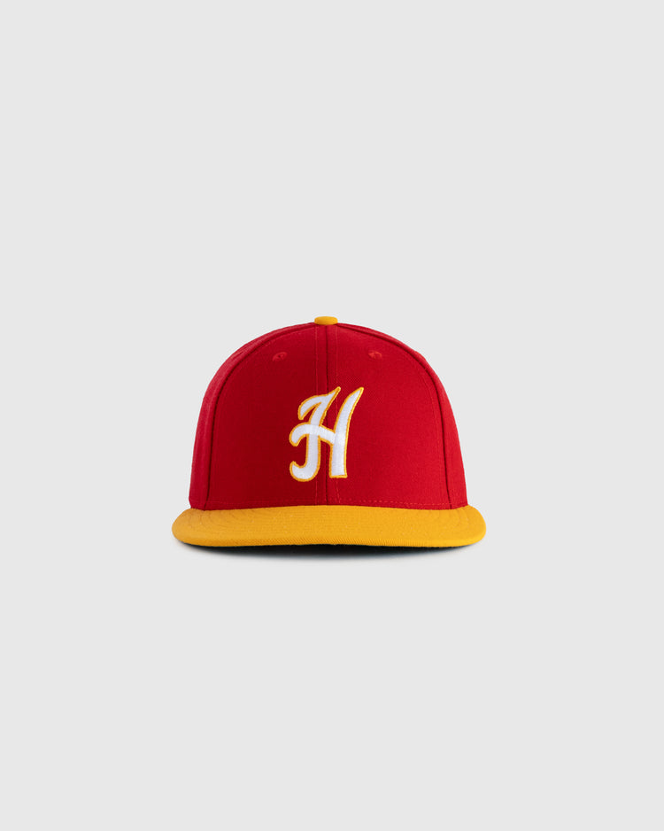 The EFF Hawaii Islanders 1986 Authentic Wool Ballcap features red wool serge, a yellow brim, and a white embroidered H on the front, inspired by the 1986 logo and shown on a plain gray background.