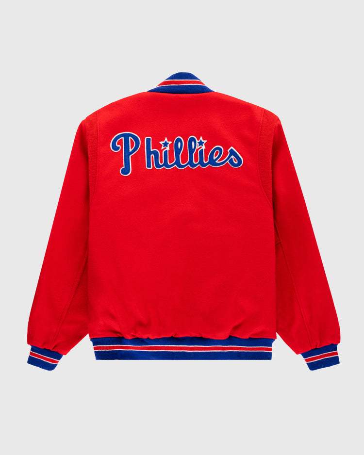 The EFF Philadelphia Phillies 1949 Authentic All Wool Varsity Jacket is a vintage red jacket with blue and white striped cuffs and collar, featuring “Phillies” in blue and white script across the back—true to the 1949 team style.