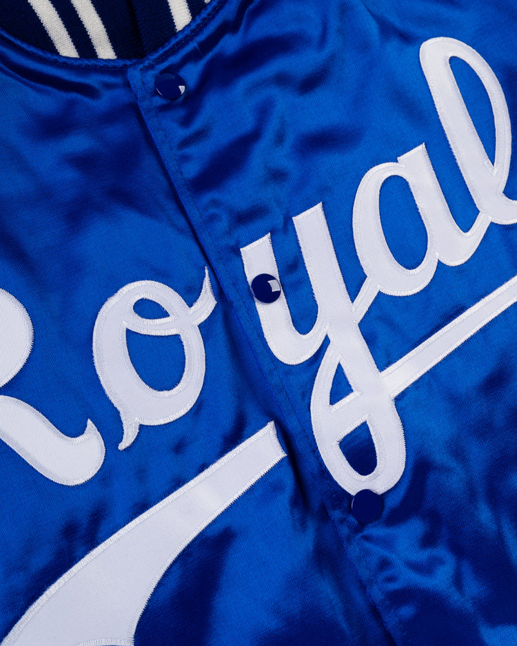 Close-up of an EFF Kansas City Royals 1969 Authentic All Satin Varsity Jacket, featuring blue satin fabric, bold white Royal script lettering, and matching blue buttons down the center.