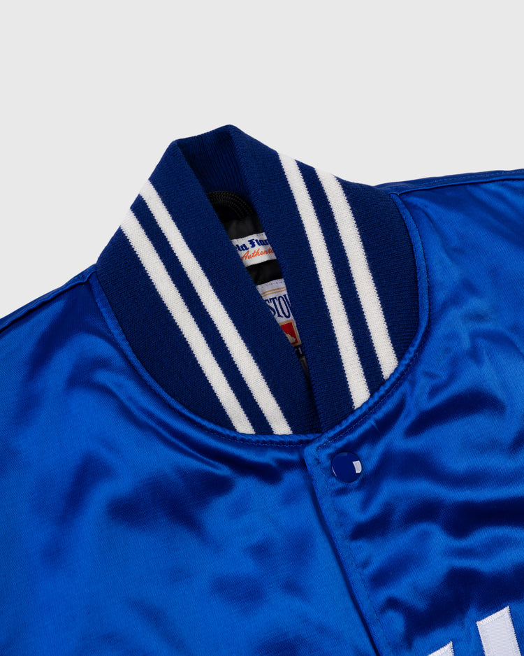 Close-up of the EFF Kansas City Royals 1969 Authentic All Satin Varsity Jacket in blue, showing its ribbed collar with white and navy stripes, snap button, and stitched white lettering.