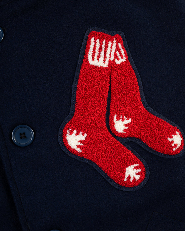 Close-up of the EFF Boston Red Sox 1938 Authentic Wool & Suede Leather Varsity Jacket in navy, featuring large black buttons and a red patch with two white-heeled socks, echoing the classic letterman style.