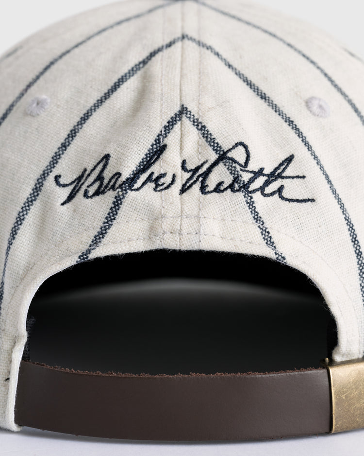 Close-up of the back of the Ebbets Field Flannels Babe Ruth 1932 Signature Series Wool Ballcap, featuring his embroidered signature, classic pinstripes, leather strap, and brass buckle—a must-have for baseball memorabilia collectors.
