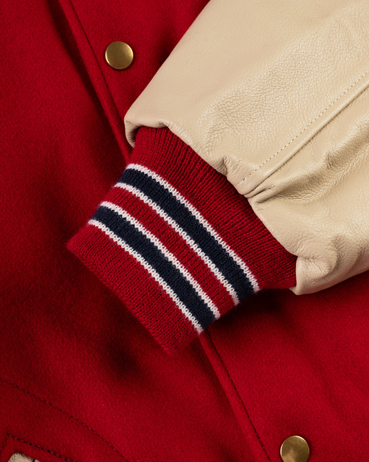 Close-up of the EFF St. Louis Cardinals 1940 Authentic Wool & Leather Jacket, featuring a red wool body, beige leather sleeve, striped ribbed cuff in team colors, and gold snap buttons for vintage varsity style.