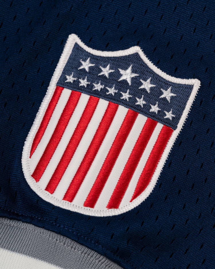 Close-up of a USA shield patch with white stars on blue and red/white stripes, stitched onto the EFF Homestead Grays Mesh V-Neck Jerseyâan homage to baseball history.