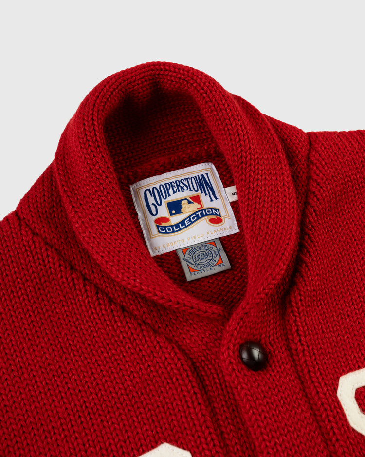Close-up of an EFF Boston Red Sox 1917 Wool Shawl Collar Sweater featuring a red knit design, black button, white letterpatch detail, and Cooperstown Collection tag in the collar—classic Dead Ball Era style.
