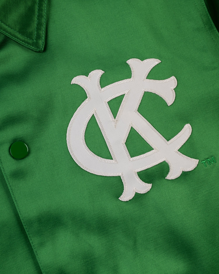 Close-up of the EFF Kansas City Athletics 1963 Satin Windbreaker Jacket, showing a large white interlocking KC logo stitched on the green front, with button and collar detailsâa classic vintage style.