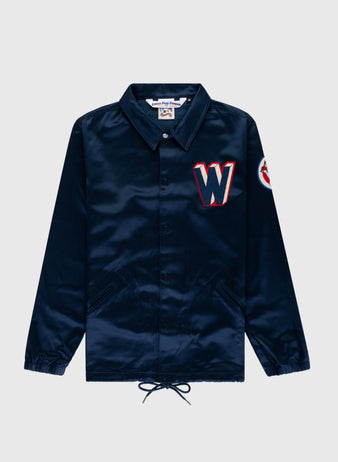 The EFF Washington Senators 1959 Satin Windbreaker Jacket is navy blue with two front pockets, a red and white “W” patch on the chest, a circular sleeve patch, collar, elastic cuffs, and a drawstring hem.