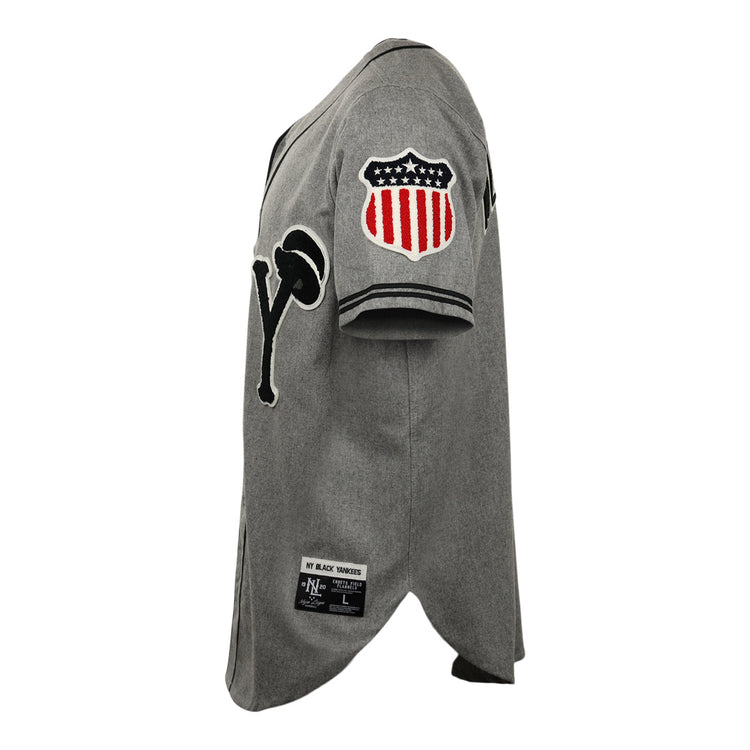 The EFF New York Black Yankees Vintage Inspired Replica Wool Jersey is gray, features a black “Y” and microphone graphic on the chest, and a red, white, and black shield patch with stars and stripes on the sleeve.