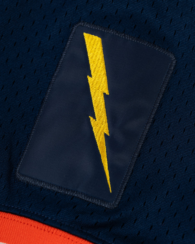 A yellow lightning bolt patch is sewn onto dark blue, perforated mesh in the EFF New York Knights Mesh V-Neck Jersey, reminiscent of vintage jerseys like those worn in The Natural.