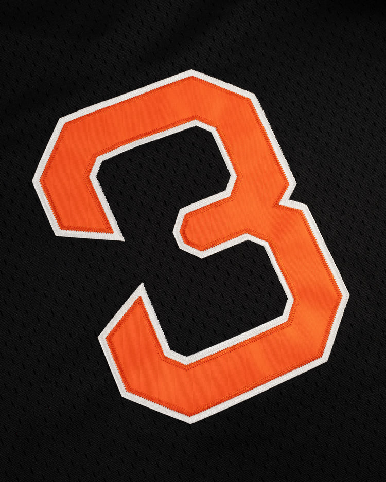 A large orange number 3 with a white outline is stitched onto black mesh on the EFF Sioux City Ghosts Mesh Button-Up Jersey, inspired by the bold uniforms of classic barnstorming softball teams.