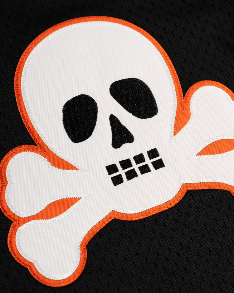 The Sioux City Ghosts Mesh Button-Up Jersey by EFF features a white skull and crossbones with an orange outline on a black textured background, inspired by the legendary Black fast-pitch softball team Sioux City Ghosts.