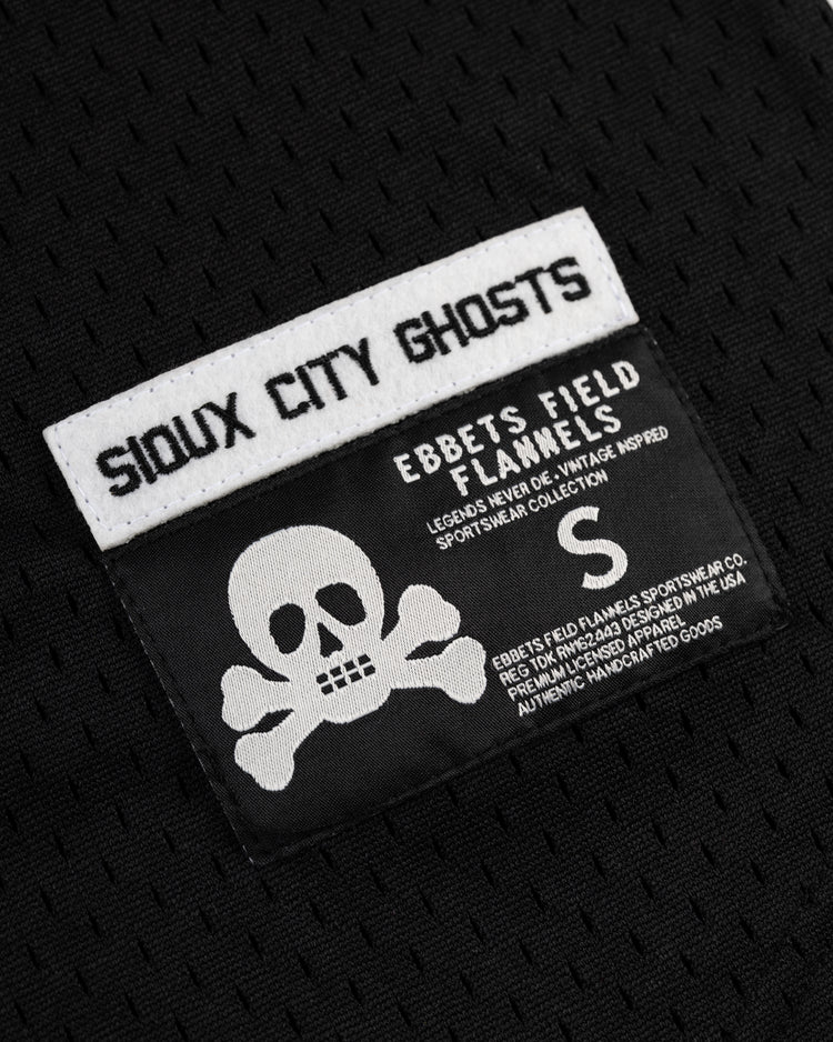 A black mesh EFF jersey displays “Sioux City Ghosts” in bold white above a label with a skull and crossbones, product info, and size “S,” all on a textured black background.