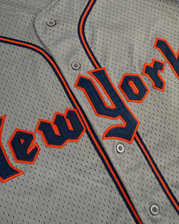 Close-up of the EFF New York Knights Mesh Button-Up Baseball Jersey, featuring New York in blue with orange trim and white buttons, inspired by the vintage Robert Redford jersey from The Natural.