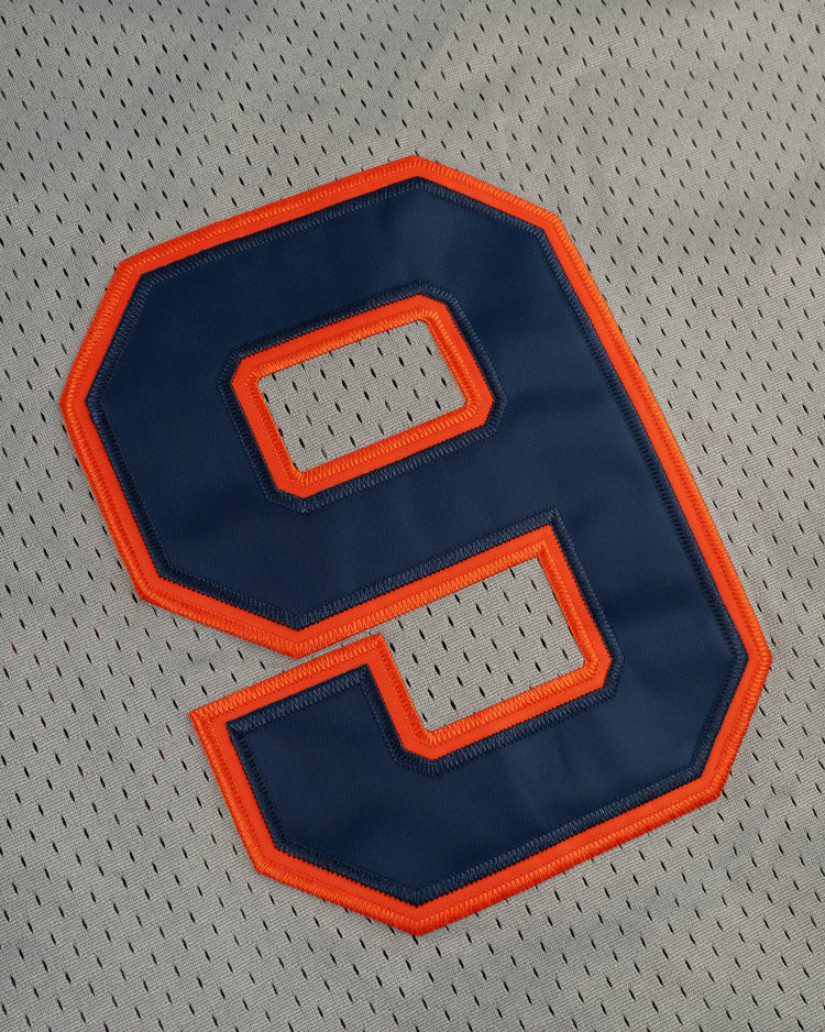 A large navy blue number 9 with an orange outline is stitched onto light gray mesh fabric, echoing vintage style on the EFF New York Knights Mesh Button-Up Baseball Jersey.