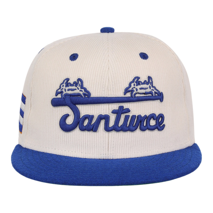 The EFF Santurce Cangrejeros NLB Ground Rule Double Fitted Ballcap features a beige crown, blue brim, Santurce script, blue crab graphics above a bat, and side stripes—ideal for Puerto Rican League fans.