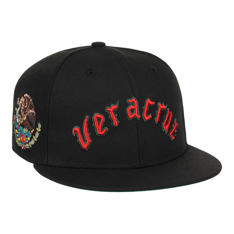 The EFF Veracruz Azules NLB Team Color Fitted Ballcap is a black hat with red gothic lettering on the front and the Mexican emblem on the side—ideal for fans wanting a vintage-inspired Mexican League style.
