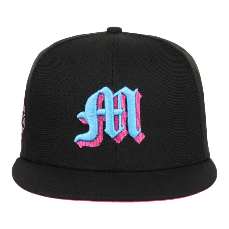The EFF Miami Giants NLB Team Color Fitted Ballcap is a vintage-inspired black cap with a large blue Old English M outlined in pink and an embroidered team logo on the front.
