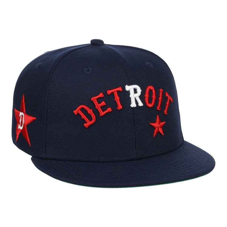 The EFF Detroit Stars NLB Team Color Fitted Ballcap is a vintage-inspired navy cap with DETROIT embroidered in red and white, red stars on the front and side, and a flat brim.