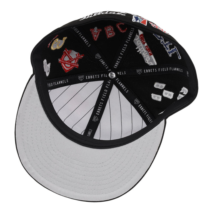 The EFF Negro League Baseball NLB Team Color Fitted Ballcap features embroidered team logos and patches, black and white colors with pinstripes on the brim, and Ebbets Field Flannels branding on the inner bands.