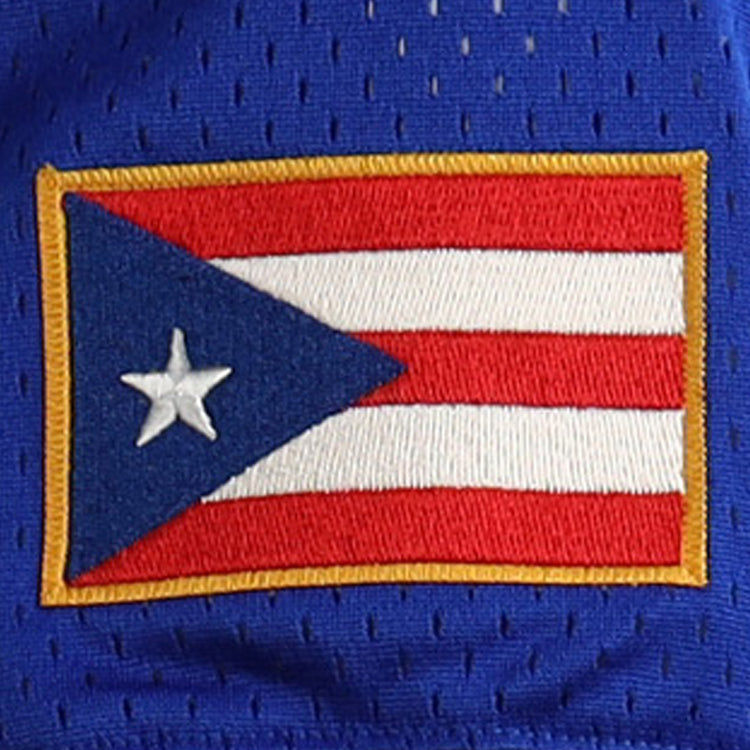 The image displays a patch of the Puerto Rican flag on blue fabric with a yellow border, reflecting EFFs Roberto Clemente Santurce Cangrejeros Vintage Inspired NL Replica V-Neck Mesh Jersey - Royal.