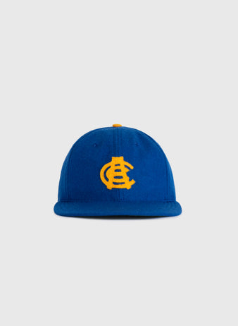 The EFF Chinese Athletic Club (Hawaii) 1910 Authentic Wool Ballcap is a blue cap with a yellow embroidered interlocking C and A logo, inspired by Hawaiian baseball history, shown against a plain light gray background.